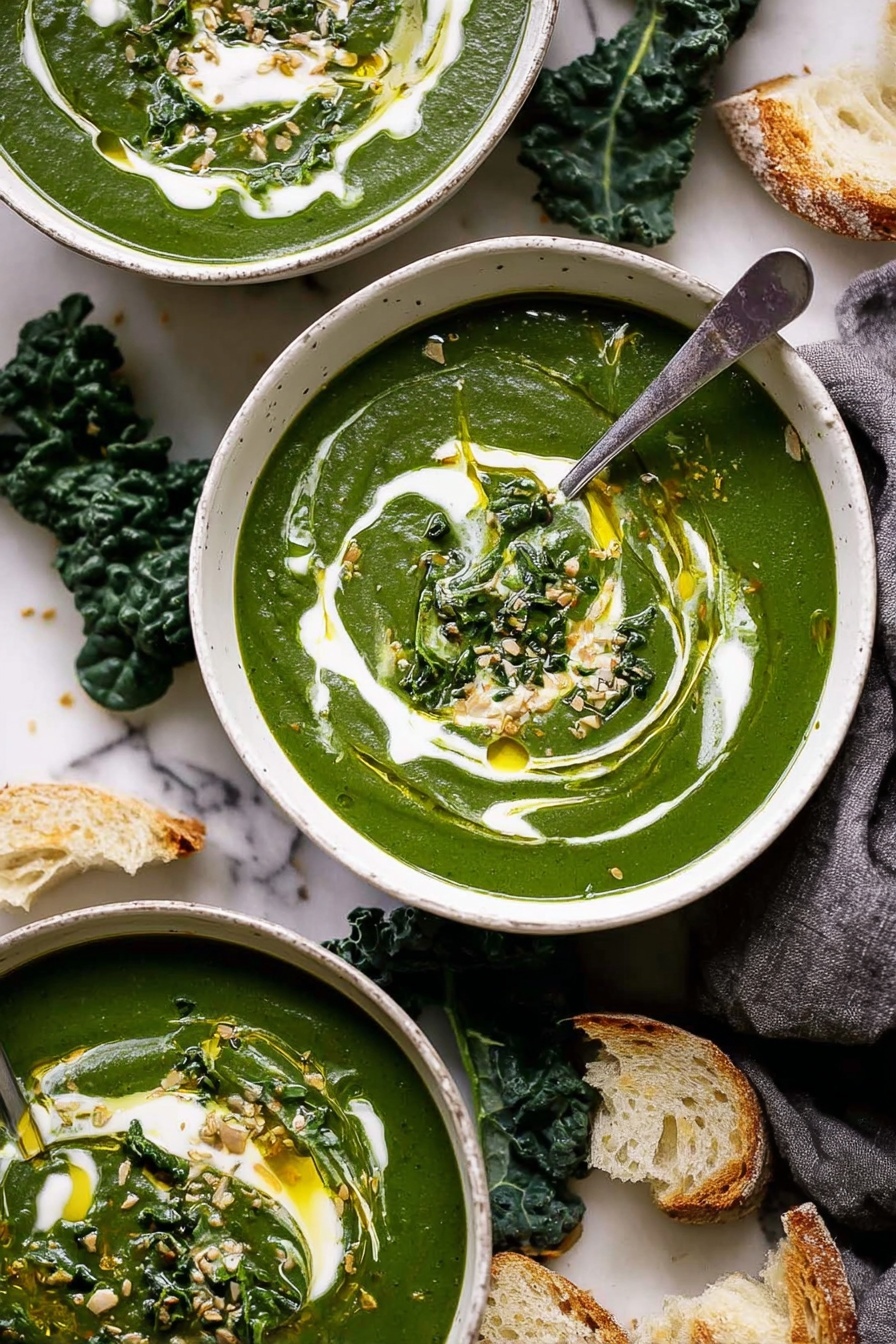 Three white bowls filled with thick green soup are set on a white marbled surface with a gray cloth. Each bowl has a swirl of white cream on top, drizzled with golden olive oil and sprinkled with light brown seeds. One bowl has a silver spoon standing upright in the soup. Fresh dark green kale leaves and pieces of torn light brown bread are scattered around the bowls. The texture of the soup is smooth and creamy with visible small bits of leafy greens. Photo taken with an iphone --ar 2:3 --v 7