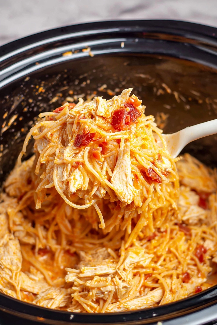A close-up image showing a white spoon lifting creamy spaghetti mixed with small red pieces of bacon and light golden cooked chicken chunks from a black slow cooker. The spaghetti is covered in a smooth orange-tinged sauce, giving a slightly shiny look to the noodles and chicken. The slow cooker has a glossy black interior with some sauce splatters on its sides. The picture is taken on a white marbled surface. photo taken with an iphone --ar 2:3 --v 7
