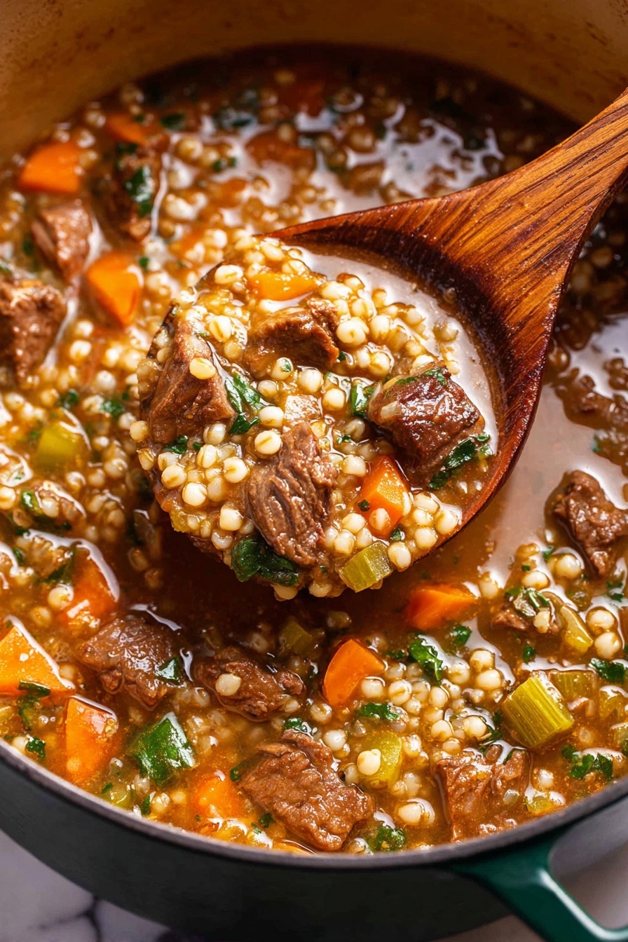 A close-up view of a thick stew filled with pearl-like grains, chunks of tender brown meat, small orange carrot pieces, and green leafy herbs and celery bits, all in a rich, brownish broth. The stew is being scooped by a wooden spoon showing the dense texture and mix of ingredients. The pot holding the stew is dark green on the outside and sits on a surface with a white marbled texture. photo taken with an iphone --ar 2:3 --v 7