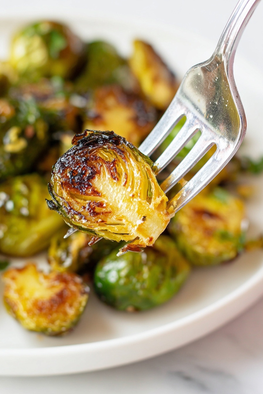 A white plate full of bright green Brussels sprouts piled high, each sprout round with tightly closed leaves and light beige cut stems facing outward, sitting on a white marbled surface. In the blurred background, there are two bottles: one bottle has an orange label with